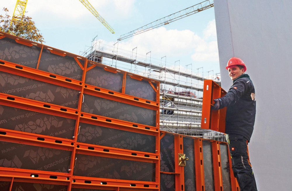 Mann trägt NeoR-Schalungselement auf der Baustelle